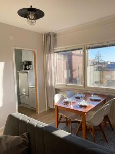 a living room with a table and chairs and a kitchen at Apartments Maaherrankatu in Kuopio