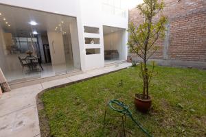 a tree in a yard next to a building at Casa completa, 5 dormitorios y jardín in Ayacucho
