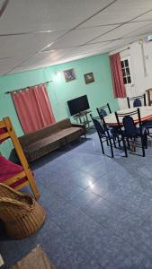 a living room with a table and chairs and a television at Cabañas El Monchito in Juana Koslay 