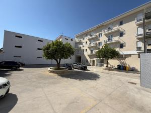 a large building with cars parked in a parking lot at ARQO Apartments in Marcianise
