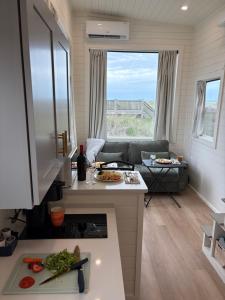 a living room with a couch and a table at Oceanfront Tiny Retreat in Holden Beach +55 photos