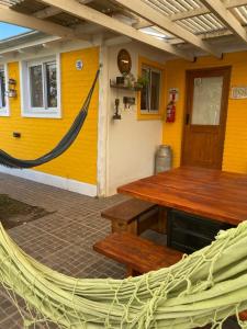 a yellow building with a wooden table and a hammock at BARRIO VIEJO in Los Reartes +288 photos