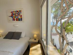 a bedroom with a bed and a large window at Stunning Intimate views. Terrace Rooftop. Wifi in Tamariu