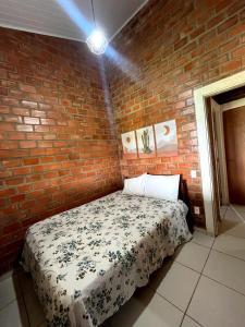 a bedroom with a bed in a brick wall at Chalés serra negra in Bezerros