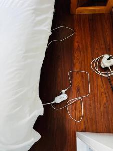a bed with a video game controller on a wooden floor at Premium Executive Room in Sandton