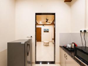 a kitchen with a stainless steel refrigerator in a room at Hotel Aventus Suites Indore in Indore