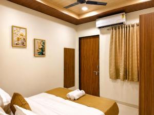 a bedroom with a bed and a ceiling fan at Hotel Aventus Suites Indore in Indore