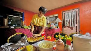 a man standing in a kitchen preparing food at Phantom rock view homestay in Namara +45 photos