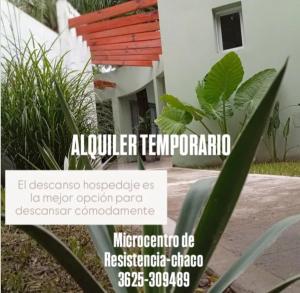 a sign in front of a house with a plant at El DESCANSO HOSPEDAJE in Resistencia