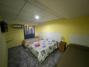 a bedroom with two beds and a television in it at Hotel Norte in Río Tercero