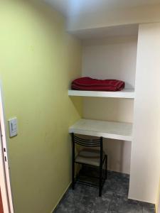 a room with a shelf with a chair and a red pillow at Hotel Norte in Río Tercero