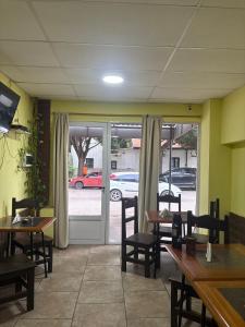 a restaurant with tables and chairs and a door to a parking lot at Hotel Norte in Río Tercero