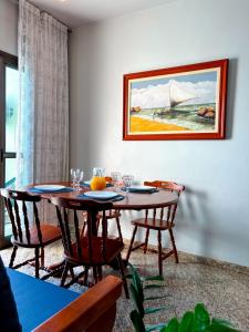 a dining room with a table with chairs and a painting at Refugio do Forte Cabo Frio in Cabo Frio