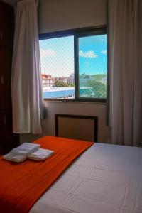 a bedroom with a bed and a window with a view at Refugio do Forte Cabo Frio in Cabo Frio +23 photos