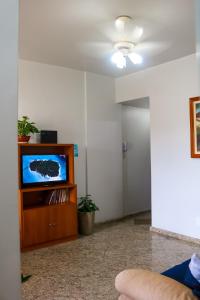 a living room with a tv on a wooden entertainment center at Refugio do Forte Cabo Frio in Cabo Frio