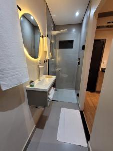 a bathroom with a sink and a mirror at Studio Moderno e Prático Wi-Fi Rápido e AC in Ribeirão Preto