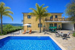 a villa with a swimming pool in front of a house at Villa Alonia in Simou