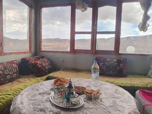 a table with food on it in a room with windows at Auberge High Atlas B&B in Alemrhou