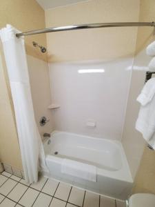 a white bathroom with a shower and a bath tub at Wingate by Wyndham Uniontown in Uniontown