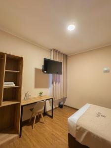 a hotel room with a bed and a desk and a tv at Andari Hoteles in Arequipa