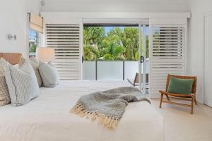 a bedroom with a large white bed with a window at Pet Friendly Modern Oasis with Private Pool in Noosaville