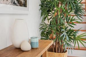 a wooden table with a vase and a plant at Pet Friendly Modern Oasis with Private Pool in Noosaville +12 photos