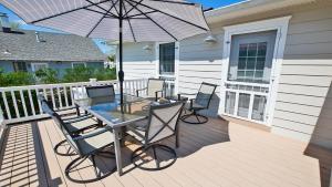 a patio with a glass table and chairs and an umbrella at Congress Cottage in Cape May