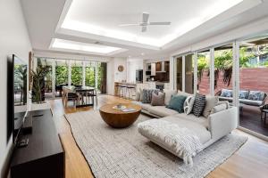 a living room with a couch and a table at Modern airy duplex steps to River heated pool in Noosaville