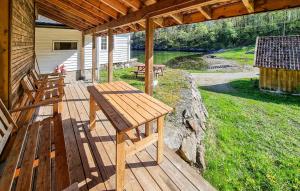 a wooden deck with a picnic table on a house at Sjøhytta in Vanvik