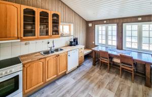a kitchen with wooden cabinets and a wooden table at Sjøhytta in Vanvik