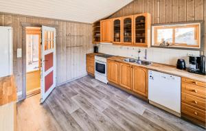 a kitchen with wooden cabinets and white appliances at Sjøhytta in Vanvik