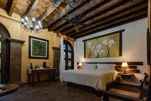 a bedroom with a bed and a chandelier at Posada de las Flores Loreto in Loreto +28 photos