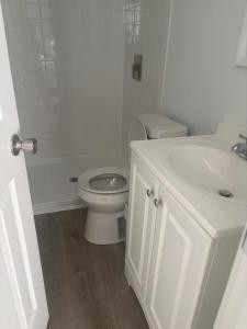 a white bathroom with a toilet and a sink at Cozy Rooms in Decatur in Decatur