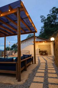 a wooden pergola with a bed on a patio at Chalé loft reserva Refúgio nas Montanhas in Marechal Floriano