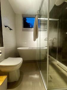 a bathroom with a tub and a toilet and a sink at Chalé loft reserva Refúgio nas Montanhas in Marechal Floriano +24 photos
