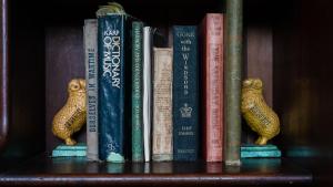 a group of books sitting on a book shelf at Kingfisher Cottage in Broughton Vale