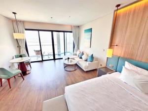 a bedroom with a large bed and a living room at À La Carte Hạ Long in Ha Long