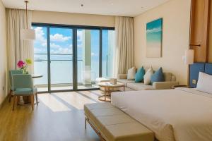 a hotel room with a bed and a large window at À La Carte Hạ Long in Ha Long