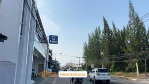 a white truck parked on a street with a sign that reads hotel entrance at Sleep Owl Surat Thani in Surat Thani