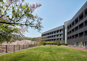 ein Bürogebäude mit einem Rasen davor in der Unterkunft Rolling Hills Hotel in Hwaseong