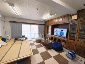 a living room with a tv and a checkered floor at Direct to Shinjuku 15 mins Up to 6Guests in Tokyo