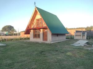 a small house with a green roof on a field at Cabaña don Cencio in San Pedro