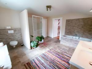 a bathroom with a tub and a toilet and a sink at Chambre d'hôtes Le Colibri in Épinal