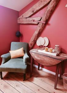 a chair and a table in a room with red walls at Chambre d'hôtes Le Colibri in Épinal