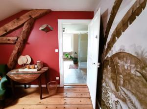 a hallway with red walls and a wooden floor at Chambre d'hôtes Le Colibri in Épinal +6 photos