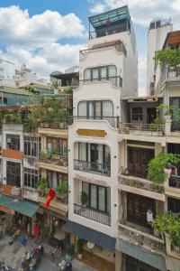 a tall white building with plants on the balconies at Home en Lagom in Hanoi