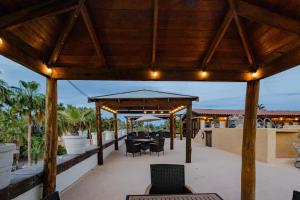 a wooden pergola with a table and chairs on a patio at Posada de las Flores Loreto in Loreto