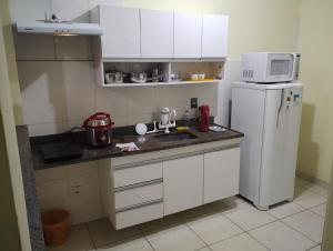 a kitchen with a white refrigerator and a microwave at Ap completo 01 quarto com ar condicionado, wi-fi in Viçosa +9 photos