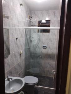 a bathroom with a shower and a toilet and a sink at Ap completo 01 quarto com ar condicionado, wi-fi in Viçosa