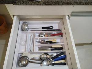 a drawer full of utensils in a cabinet at Ap completo 01 quarto com ar condicionado, wi-fi in Viçosa
